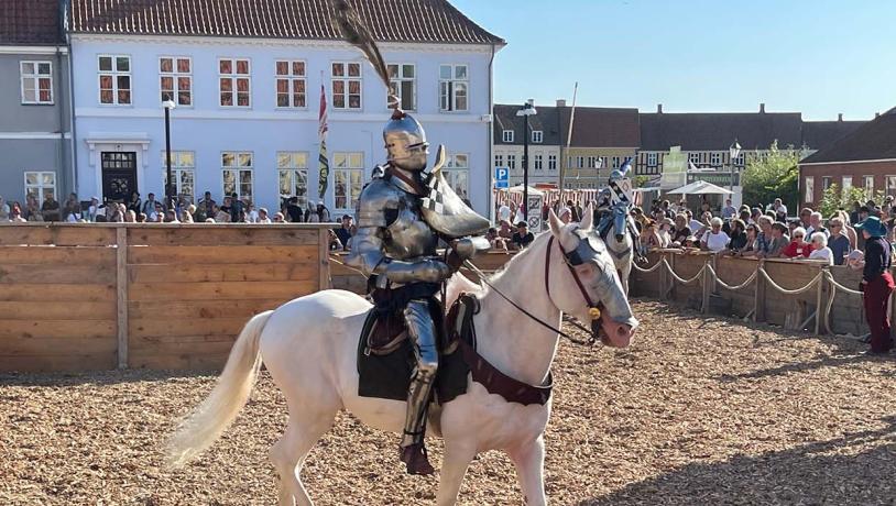 Ridder på hvid hest til lansedystturnering