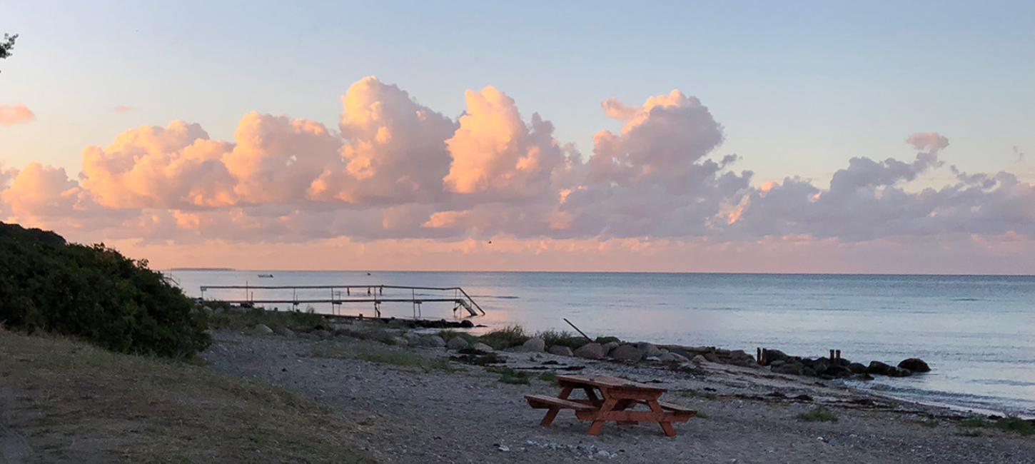 Strand i Nyborg med røde skyer på himlen