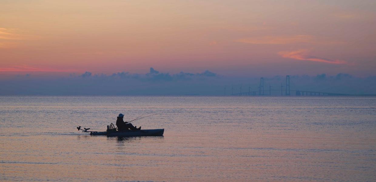 En kajakroer nyder en stille morgenstund i Storebælt