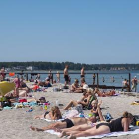 Badende turister på Fyns Badestrand ud til Storebælt